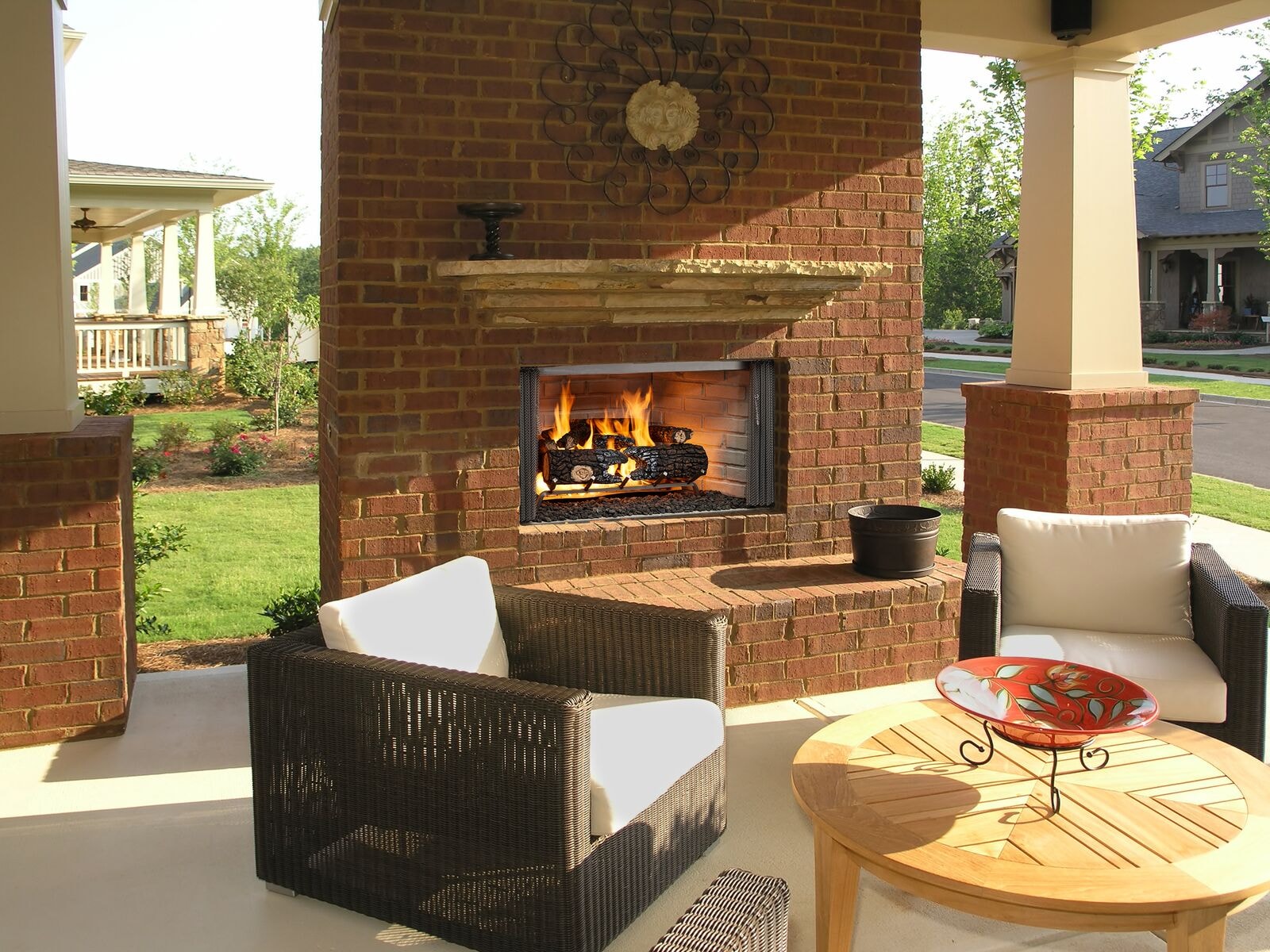 Majestic Villawood outdoor wood-burning fireplace on covered porch with wicker seating